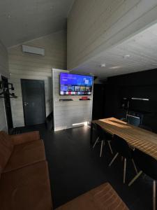 a conference room with a table and a tv on a wall at Himos Siesta Porealtaalla ja loppusiivouksella in Jämsä
