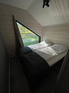 a bed in a small room with a window at Himos Siesta Porealtaalla ja loppusiivouksella in Jämsä