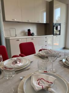a table with plates and wine glasses on it at Helle, gemütliche Wohnung in Sommer-Freibadnähe in Origgio +35 photos