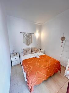 a bedroom with a bed with an orange blanket on it at T1 na 1 linha da Praia da Rocha in Portimão