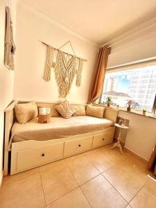 a bed in a room with a window at T1 na 1 linha da Praia da Rocha in Portimão