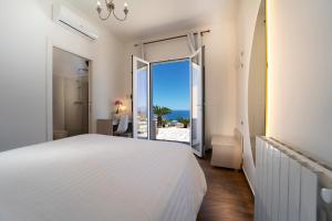 a bedroom with a bed and a view of the ocean at Hotel Antica Cascina Del Golfo in Scopello +37 photos