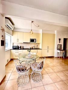a kitchen with a glass table and chairs at T1 na 1 linha da Praia da Rocha in Portimão
