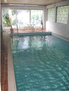 a swimming pool in a house with a table and chairs at Pension Stiegelmeier in Winterberg