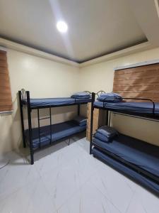 a room with three bunk beds in a room at BenRitz Transient House in Urdaneta