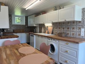 eine Küche mit weißen Schränken und einem Tisch mit einer Waschmaschine in der Unterkunft MAISON DE FAMILLE ENTRE MER ET CAMPAGNE à 5 MN DE LA PLAGE in Blainville-sur-Mer