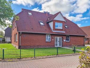 a red brick house with a red roof at Silbermöwe in Greetsiel