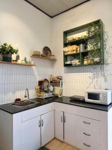 une cuisine avec des armoires blanches et un comptoir noir dans l'établissement Hiên Stay, à Xuan An