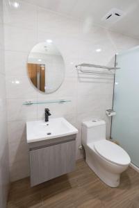 a bathroom with a toilet and a sink and a mirror at 戀海輕旅Ocean Pride Hostel in Xiaoliuqiu