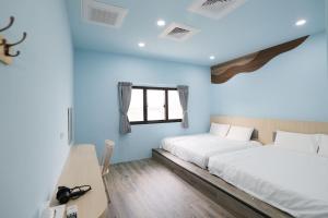 two beds in a room with blue walls at 戀海輕旅Ocean Pride Hostel in Xiaoliuqiu