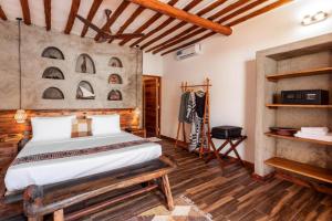 a bedroom with a large bed and wooden floors at Ananda Beach Hotel in Paje