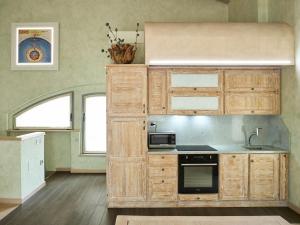 a kitchen with wooden cabinets and a stove top oven at Avveduti Boutique Apartment in Fano