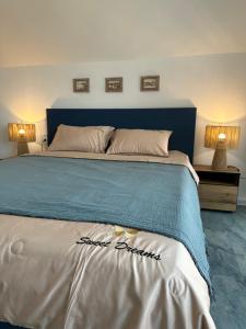 a bedroom with a large bed with a blue headboard at SummerBlue - Синьо лято in Lozenets