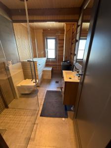 a bathroom with a tub and a toilet and a sink at Nordic Gateway Logde in Hafjell