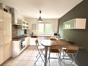 a kitchen with a wooden table and chairs at M057 Joli T3 proche de la frontière in Annemasse +4 photos