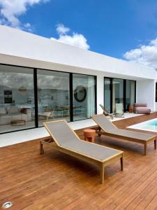 a house with two lounge chairs and a pool at Villa Lima by Aura Collection in La Oliva