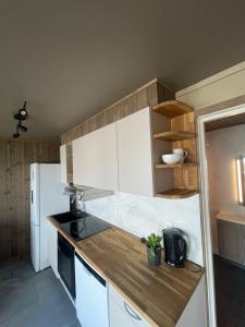 a kitchen with white cabinets and a white refrigerator at Appartment in beautiful nature in Bodø +7 photos