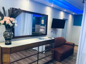 a room with a mirror and a couch and a vase with flowers at Flat do Bispo in Uberlândia