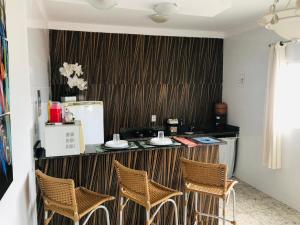 a kitchen with a counter with four chairs in it at Flat do Bispo in Uberlândia
