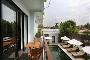 a balcony with tables and chairs and a swimming pool at Sam So Boutique Villa in Siem Reap