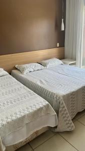 two beds sitting next to each other in a bedroom at Flat Village - Aldeia das Águas C202 in Barra do Piraí