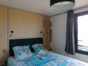 sypialnia z łóżkiem z niebieskimi poduszkami w obiekcie Chalet enchanteur à Arzal avec vue sur lac et piscine partagée w mieście Arzal +20 zdjęć