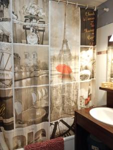 a bathroom with a shower curtain with an image of the eiffel tower at B201 Studio 10 min DisneyLand Paris in Montévrain +2 photos