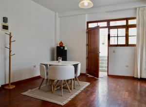a table and chairs in a room with a door at Mirandoelmar Apartment - SOL in Lima