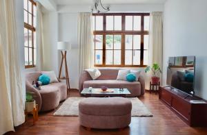 a living room with two couches and a tv at Mirandoelmar Apartment - SOL in Lima