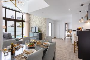 Laguna Beach Villa Veintidos في توريفايجا: غرفة طعام وغرفة معيشة مع طاولة وكراسي