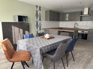 a kitchen with a table with chairs and a table cloth at Cocon lumineux, tout confort in Aiglemont
