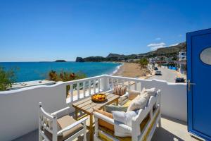 a balcony with chairs and a table and a view of the beach at Hermes Seaview House in Archangelos