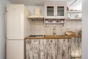 a kitchen with a white refrigerator and a sink at Hermes Seaview House in Archangelos