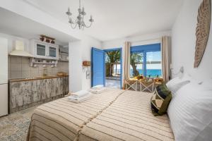 a bedroom with a large bed with a view of the ocean at Hermes Seaview House in Archangelos
