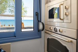 a kitchen with a window next to a oven at Hermes Seaview House in Archangelos +26 photos