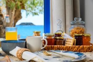 a table with a plate of food and a drink at Hermes Seaview House in Archangelos