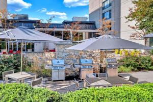 a patio with tables and chairs and umbrellas at Contemporary Apt Near DC Gym, Metro & More! in Arlington