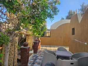 an outdoor patio with chairs and a building at Badry Sahara Camp in Bawati