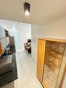 a kitchen and dining room with a glass cabinet at Melhores Flats - Encanto a 5 min da praia de Tambaú in João Pessoa