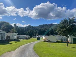 a gravel road leading to a campsite with a mountain at Faskally Woods Holiday Park in Pitlochry +10 photos