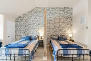 zwei Betten in einem Zimmer mit einer Ziegelwand in der Unterkunft Sunset Serenity!!-Tropical Waterfront Oasis-Huge Private Patio-10Min to KingSt & Beaches in Charleston