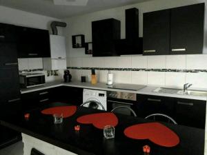 a kitchen with black and white appliances and red counter tops at Apartment Bella Italia in Cologne