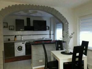 a kitchen with a table and a washing machine at Apartment Bella Italia in Cologne