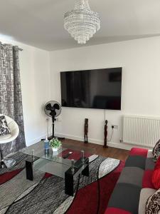 a living room with a couch and a glass table at Milton Keynes Homely Luxury Flat in Wolverton