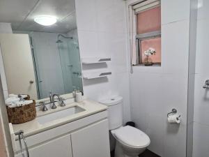 a white bathroom with a toilet and a sink at Eliza's Island in Sydney +8 photos