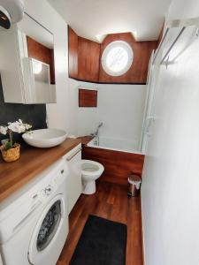een badkamer met een wasmachine en een wastafel bij escapade à Wimereux in Wimereux