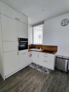 een witte keuken met een spoelbak en een magnetron bij escapade à Wimereux in Wimereux