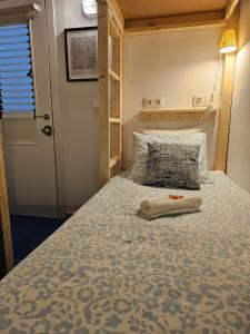 a small bedroom with a bed with a pillow at Blue Mango Surf House Center in Puerto del Rosario