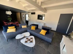 a living room with a blue couch and yellow pillows at Villa La Bosse Ile de Noirmoutier pour 10 personnes in LʼÉpine