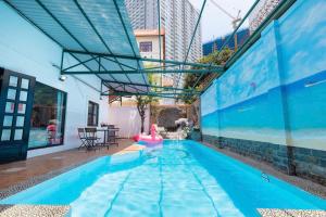 a large swimming pool with a pool noodle in a building at Kegotel Villa Bãi Sau ngay Tháp Tam Thắng in Vung Tau